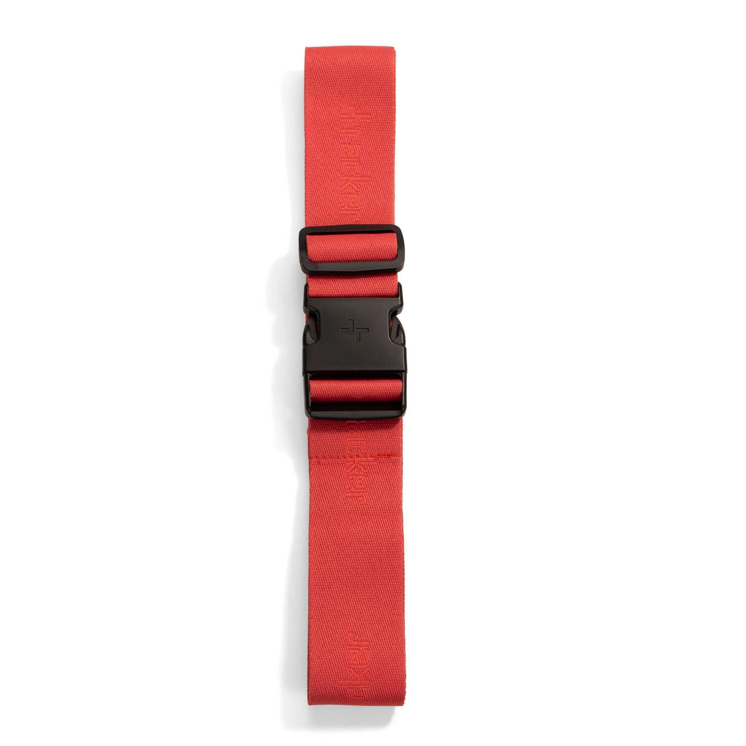 Coral luggage strap designed by Tracker called Tracker Logo folded and buckled showing the tracker logo pattern printed on the entirety of the polyester.